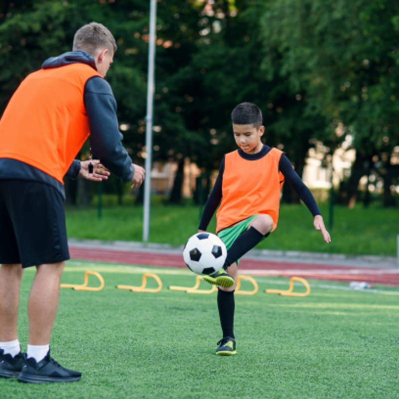 player-football-uniform-working-out-kicking-ball-with-coach-stadium